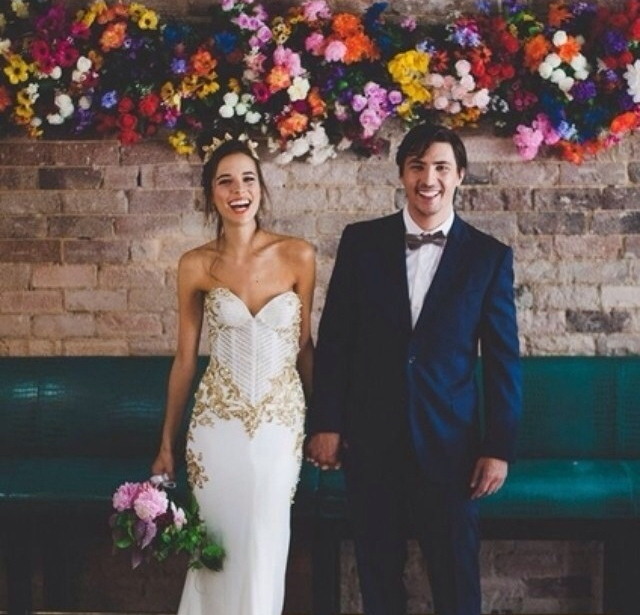 groom, flower wall and bride