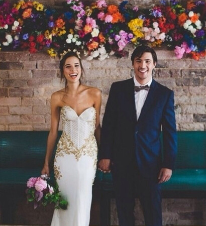 groom, flower wall and bride